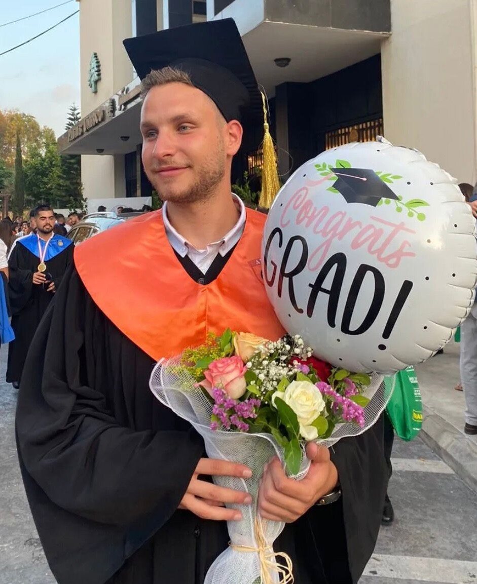 Graduate celebrating with flowers